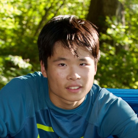 Zander Kwan sitting in a hammock in a forest